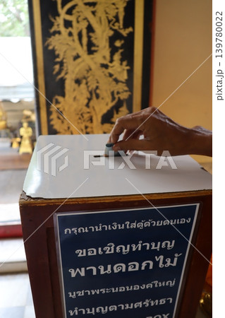 Hand Depositing Offering into Temple Donation Box Hand Depositing Offering into Temple Donation Box 139780022