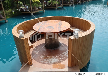 Circular Poolside Seating with Wooden Table in Turquoise Water Circular Poolside Seating with Wooden Table in Turquoise Water 139780044