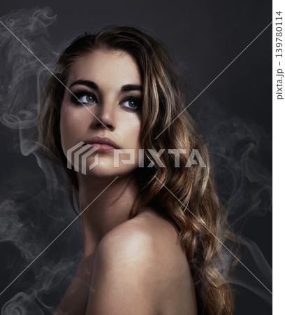 Woman, thinking and makeup, beauty and smoke with hair, cosmetics and balayage on grey background. Serious model, edgy with haircare and vapor, cosmetology and dream with mist or fog in studio 139780114