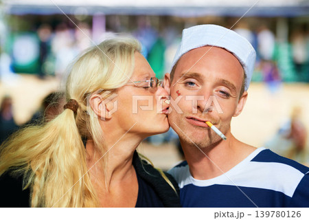 Couple, music festival and happiness with kissing, portrait or bonding together with weekend break. Face, people or friends with joy or concert with a party or outdoor with fun or costume with summer 139780126