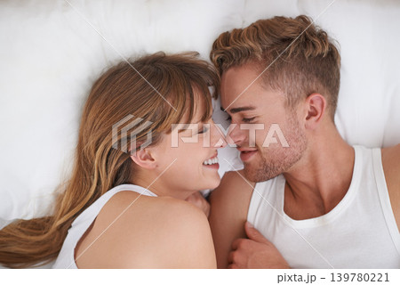 Couple, love and relaxing in bed on weekend, happy and bonding or care in relationship at home. People, loyalty and commitment to marriage in bedroom, smiling and romance or comfortable and lazy Couple, love and relaxing in bed on weekend, happy and bonding or care in relationship at home. People, loyalty and commitment to marriage in bedroom, smiling and romance or comfortable and lazy 139780221