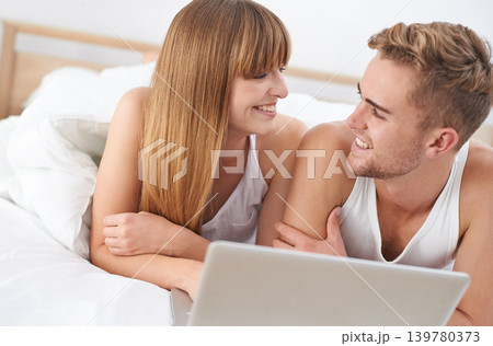 Happy, couple and relax on laptop in bed to watch movies with subscription for streaming in home. Smile, man and woman in bedroom with computer for website, blog or social media on internet Happy, couple and relax on laptop in bed to watch movies with subscription for streaming in home. Smile, man and woman in bedroom with computer for website, blog or social media on internet 139780373