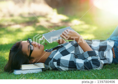 Relax, grass or woman in park reading book for learning knowledge, information or education. Thinking, textbook or female student in nature for studying history, story or novel on college campus lawn Relax, grass or woman in park reading book for learning knowledge, information or education. Thinking, textbook or female student in nature for studying history, story or novel on college campus lawn 139780406
