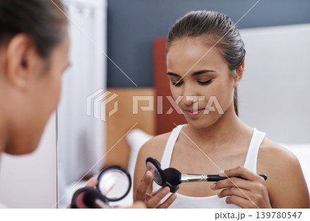 Woman, makeup and mirror for date, cosmetic or interview for fashion artist. Female, blush and eyeshadow for beauty, self care and foundation in bedroom to prepare for graduation and after party Woman, makeup and mirror for date, cosmetic or interview for fashion artist. Female, blush and eyeshadow for beauty, self care and foundation in bedroom to prepare for graduation and after party 139780547