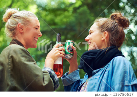 Friends, cheers and drinks at music festival in forest, excited and beer for bonding together by trees. Women, drinking and celebration in summer on holiday adventure and reunion by concert in woods 139780617