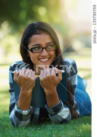 Happy woman, student and relax with book for reading, literature or studying on green grass. Young nerd, geek or female person with smile and glasses for chapter, learning or outdoor story in nature Happy woman, student and relax with book for reading, literature or studying on green grass. Young nerd, geek or female person with smile and glasses for chapter, learning or outdoor story in nature 139780769