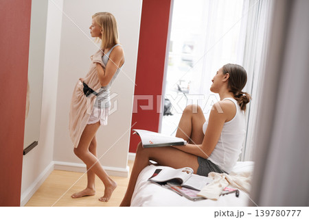 Female, friends and dress in bedroom, mirror and choice at home for style and beauty. Woman, smile and fashion to show, wear and impress for agency or excited for appointment classy event or date 139780777