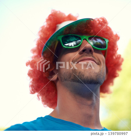 Man, wig and sunglasses with nature, sky and festival for fun, joy and celebration. Person, summer and concert with low angle, smile and happy for event, party or sunshine for celebration and closeup 139780997