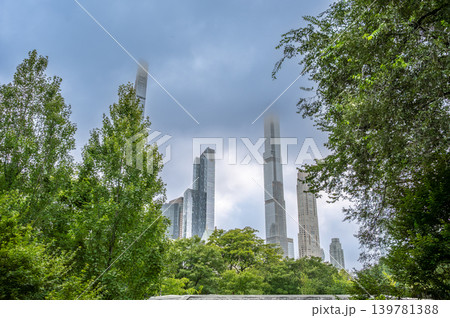 New york, usa august 18,2024. Manhattan skyline rising above central park trees, skyscraper tops shrouded in low clouds and soft urban fog in new york city New york, usa august 18,2024. Manhattan skyline rising above central park trees, skyscraper tops shrouded in low clouds and soft urban fog in new york city 139781388