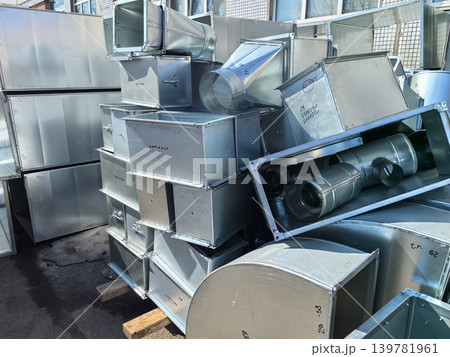 Industrial metal ducts piled high in a bustling construction site 139781961
