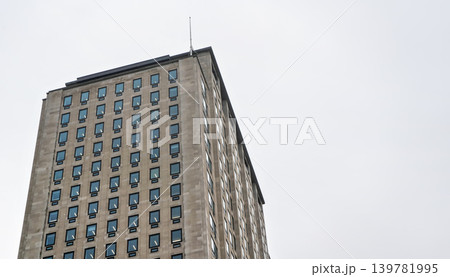 Regular rectangular windows on block of flats / offices building. Overcast sky background 139781995