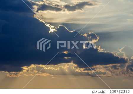 Panorama of sky at sunrise or sunset. Beautiful view of dark blue clouds lit by bright orange yellow sun on clear sky. Beauty and power of nature, meteorology and climate changing concept. Panorama of sky at sunrise or sunset. Beautiful view of dark blue clouds lit by bright orange yellow sun on clear sky. Beauty and power of nature, meteorology and climate changing concept. 139782356