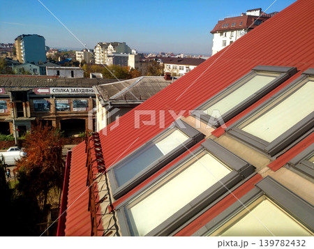 KYIV, UKRAINE - March 30, 2018: Red tiled house roof with attic windows. Roofing construction, window installation, modern architecture concept. KYIV, UKRAINE - March 30, 2018: Red tiled house roof with attic windows. Roofing construction, window installation, modern architecture concept. 139782432