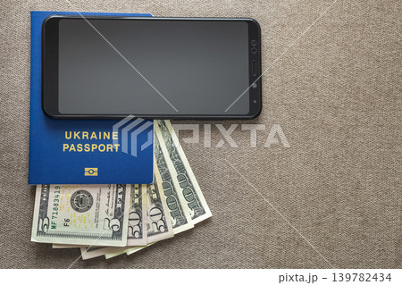 Modern black cellphone, money dollars banknotes bills and travel passport on copy space background. Travelling light, comfortable journey concept. 139782434