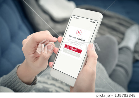 Failed online payment on smartphone screen in woman hands at home Failed online payment on smartphone screen in woman hands at home 139782849