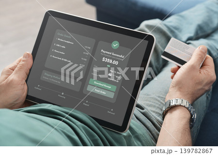 Man Holding Tablet with Payment Successful Screen at Home 139782867