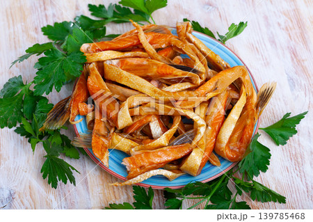 Smoked salmon belly strips on plate on wooden table 139785468