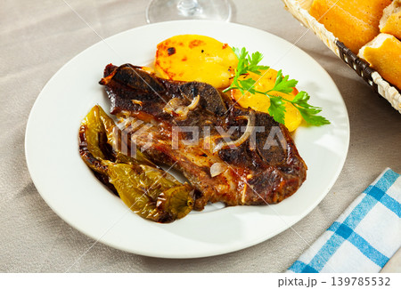 Tasty beef baked with potatoes and stewed peppers served Tasty beef baked with potatoes and stewed peppers served 139785532
