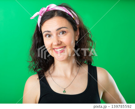 Portrait of adult woman expressing happy emotions on green background 139785592