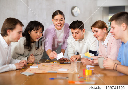 Happy girl student playing board game with friends 139785593