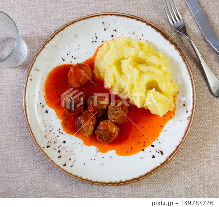 Nice tasty meatballs served with mashed potatoes and gravy on side 139785726