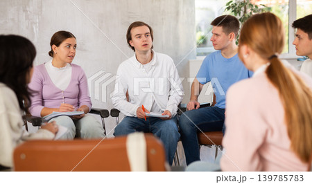 Group of students preparing for exam together in classroom of college Group of students preparing for exam together in classroom of college 139785783