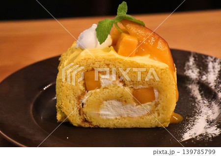 マンゴークリームが彩るロールケーキのスイーツ マンゴークリームが彩るロールケーキのスイーツ 139785799