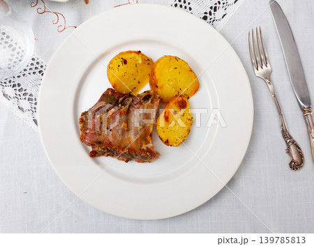 Roasted pork ribs with side dish of fried potatoes 139785813