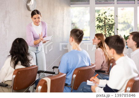 While working in classroom, female teacher answers questions that students had while studying new lesson 139785846