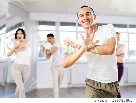 Guy with team of young like-minded people learn to dance modern dances 139785866
