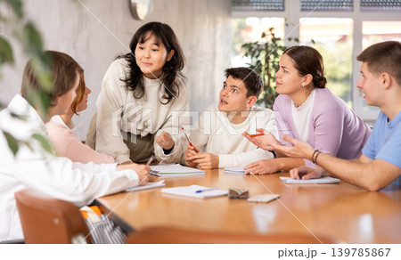 Young Asian female student taking part in group discussion Young Asian female student taking part in group discussion 139785867