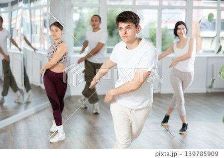 Enthusiastic Hispanic guy energizing group during fitness class Enthusiastic Hispanic guy energizing group during fitness class 139785909