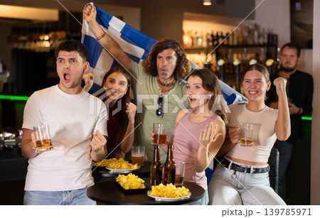Group of fans in bar with Greek flag Group of fans in bar with Greek flag 139785971