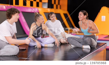 Two women and two teenager boys talking in trampoline center Two women and two teenager boys talking in trampoline center 139785988
