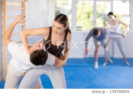Self defense lesson - woman learns to fight back an attacking man 139786002