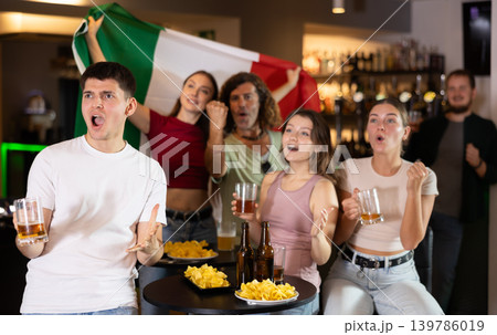 Italian fans with Italian flag emotionally watch the match on TV in pizzeria Italian fans with Italian flag emotionally watch the match on TV in pizzeria 139786019
