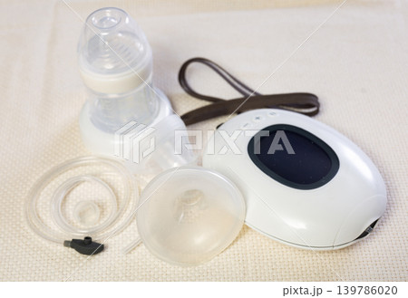 Isolated electric portable breast pump with blank bottle and replaceable nipple for feeding newborn Isolated electric portable breast pump with blank bottle and replaceable nipple for feeding newborn 139786020