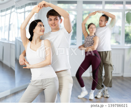 Girl paired up with young man, they train to perform disco fox dance, rehearse performance. Girl paired up with young man, they train to perform disco fox dance, rehearse performance. 139786021