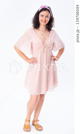 Portrait of an attractive adult woman in a pink dress on white background 139786084