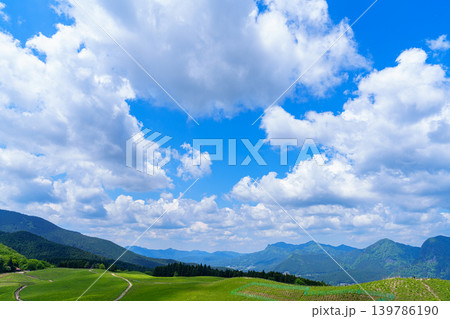初夏の曾爾高原 亀山峠へ向かう登山道の中腹から見た高原の風景 遠景の山並み上空に広がる空① 初夏の曾爾高原 亀山峠へ向かう登山道の中腹から見た高原の風景 遠景の山並み上空に広がる空① 139786190