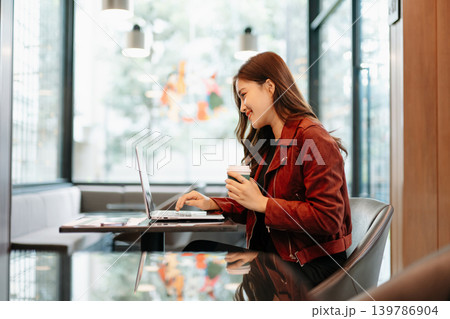 Asian Businesswoman Analyzing Financial Data Reports in Modern Cafe Asian Businesswoman Analyzing Financial Data Reports in Modern Cafe 139786904