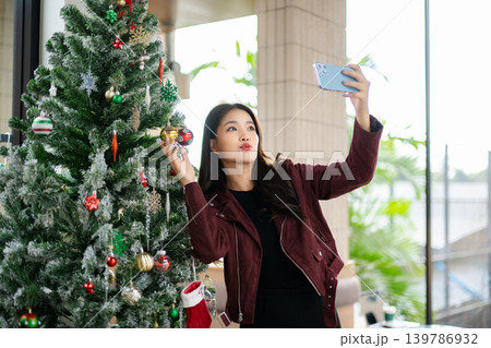 Asian Woman Decorating Christmas Tree at Home | Festive Holiday Lifestyle and Seasonal Celebration Asian Woman Decorating Christmas Tree at Home | Festive Holiday Lifestyle and Seasonal Celebration 139786932
