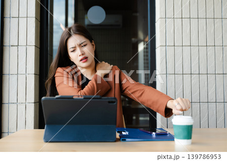 Overworked young Asian businesswoman office worker suffering from neck pain after had a long day at her office desk. office syndrome 139786953