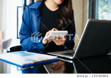 Businesswoman hand working digital marketing media in virtual screen with mobile phone and modern compute with VR icon diagram at office in morning light 139786964