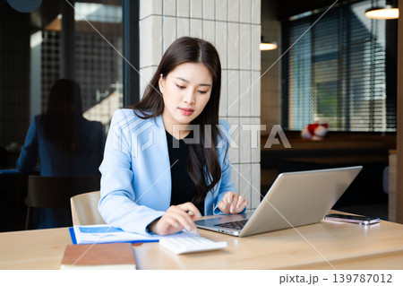 Business woman using tablet and laptop for doing math finance on an office desk, tax, report, accounting, statistics, and analytical research concept 139787012