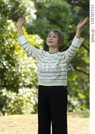 新緑の公園で散歩するシニア女性 新緑の公園で散歩するシニア女性 139787155