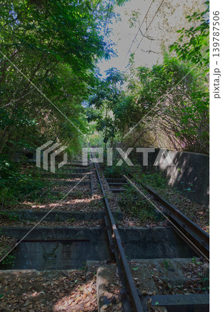 香川県高松市の旧屋島ケーブル（屋島登山鉄道）跡に遺る緑に包まれた廃線レールと石段 139787506