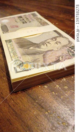 机に置かれた100万円のお札の札束 机に置かれた100万円のお札の札束 139788278