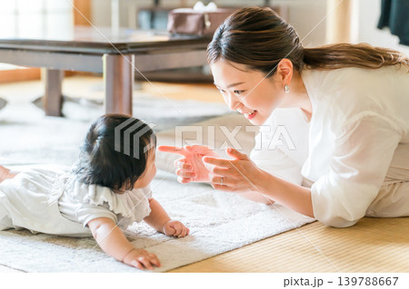 ハイハイをする赤ちゃんと笑顔のママ,子どもと遊ぶ母親 139788667
