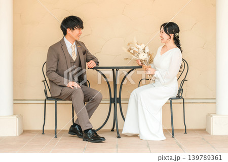 パーティー,社交パーティー会場でテーブルに座りながら会話するカップル パーティー,社交パーティー会場でテーブルに座りながら会話するカップル 139789361